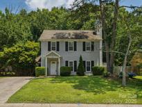 Charming two-story home featuring a well-manicured lawn, a symmetrical facade, and lush surrounding greenery at 3313 Fortis Ln, Matthews, NC 28105