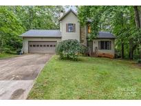 Charming home featuring a two-car garage, stone accents, mature landscaping, and a cozy covered porch at 3884 Snider Cir, Hickory, NC 28602