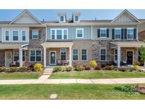Charming townhome with a well-manicured lawn, inviting front porch and eye-catching architectural details at 5432 Kinsbridge Dr, Charlotte, NC 28227