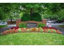 Community entrance sign with brick pillars and colorful flower bed landscaping at 5601 Fairview Rd # 11, Charlotte, NC 28209