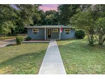 Charming single-story home boasts a freshly painted exterior, manicured lawn and inviting walkway at 112 Lineberger St, Stanley, NC 28164