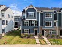 Inviting blue townhome with brick accents and a well-manicured lawn at 120 August Ln, Stallings, NC 28104