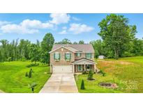 Charming two-story brick home with green shutters and a well-manicured front yard on a sunny day at 124 Vintage Woods Ct, Shelby, NC 28150