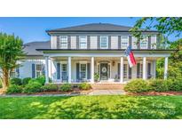 Charming two-story home with a welcoming front porch, rocking chairs, and manicured landscaping at 19625 Callaway Hills Ln, Davidson, NC 28036