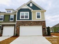 New two-story home with a stone facade, two-car garage, and a mix of siding colors at 222 Harpers Run Ln, Matthews, NC 28104