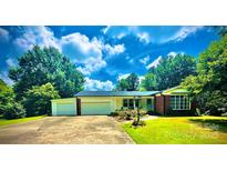 Charming single-story home with an attached garage and a well-maintained lawn and garden in a treed neighborhood at 2405 Forrestbrook Dr, Kannapolis, NC 28083