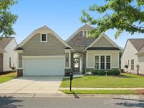 Charming single-Gathering home with manicured lawn, stone accents, and a two-car garage at 26444 Sandpiper Ct, Fort Mill, SC 29707