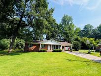 Charming brick home with a lush green lawn and mature trees at 316 Meadowood Cir, Kannapolis, NC 28081