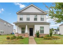 Charming two-story home featuring a covered porch with stone accents and well-manicured landscaping at 422 Nixon Rd, Belmont, NC 28012