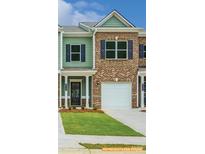 Charming townhome exterior with a well-manicured lawn and a combination of brick and siding at 6013 Jasmine Branch Rd, Charlotte, NC 28216