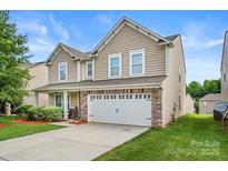 Inviting two-story home featuring a manicured lawn, a two car garage and stone accents at 6510 Nathan Dr # 78, Charlotte, NC 28269