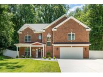 Charming two-story brick home featuring a manicured lawn, a two-car garage, and a welcoming front porch at 8418 Knollwood Cir, Charlotte, NC 28213