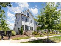 Charming two-story townhome features white siding, black trim, and manicured landscaping at 11938 Fiddlers Roof Ln, Charlotte, NC 28277