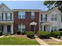Charming brick townhouse featuring a well-manicured lawn and neatly trimmed shrubbery at 12564 Jessica Pl, Charlotte, NC 28269