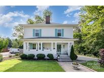 Charming two-story home with light siding, brick chimney, manicured lawn, and welcoming front porch at 132 N Confederate Ave, Rock Hill, SC 29730