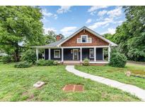 Charming home featuring a covered front porch, brown shingles, and a well-maintained yard at 14115 Old Statesville Rd, Huntersville, NC 28078