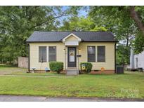Charming yellow home featuring a welcoming entrance, well-maintained lawn, and mature trees at 1425 3Rd Street Ne Pl # 9-10, Hickory, NC 28601