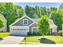 Charming home with a two-car garage, stone accents, manicured lawn, and mature tree at 14727 Brannock Hills Dr, Charlotte, NC 28278