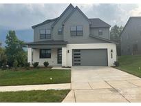 Two-story home with a modern garage, well-manicured lawn, and neutral color scheme at 15005 Brownleigh Ln # 27, Huntersville, NC 28078