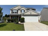 Charming two-story home featuring a manicured lawn and a spacious two-car garage at 1583 Cold Creek Pl, Huntersville, NC 28078