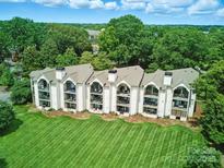 A beautiful aerial view of a condo building featuring a lush green lawn and tree-lined surroundings at 18817 Nautical Dr # 302, Cornelius, NC 28031