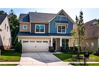 Charming two-story home with a well-manicured lawn, inviting curb appeal, and a two car garage at 203 Rustling Waters Dr, Mooresville, NC 28117