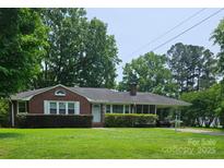 Charming brick home with well-manicured lawn and mature trees in a quiet, residential neighborhood at 205 Hillcrest Ave, Rock Hill, SC 29732