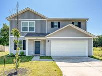 Charming two-story home with a well-maintained lawn and attached two-car garage on a bright day at 323 J C Dellinger Rd, Cherryville, NC 28021