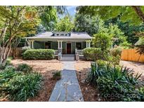 Charming one story home featuring a landscaped front yard with a stone walkway and covered porch at 506 Clement Ave, Charlotte, NC 28204