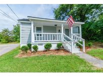 Charming home with covered porch, landscaped front yard, and American flag at 515 Myrtle Ave, Chester, SC 29706
