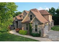 Beautiful brick and stone home with a well-manicured lawn and attached two car garage at 6302 Dwayne Starnes Dr, Hickory, NC 28602