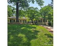 Charming ranch-style home with lush front lawn and mature trees providing shade at 695 Knollcrest Ne Dr, Concord, NC 28025