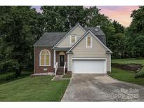 Charming home featuring a brick and vinyl facade, two car garage and an inviting front lawn at 7114 Kinsmore Ln, Charlotte, NC 28269
