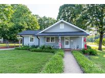 Charming single-story home featuring a cozy front porch with rocking chairs and a well-maintained lawn at 100 S Rudisill Ave, Cherryville, NC 28021
