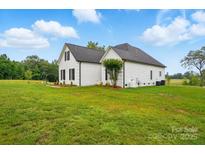 Charming exterior view of a two-story home with white brick and siding, complemented by a lush green lawn at 116 Eve Ash Ln, Mooresville, NC 28115
