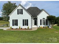 Charming white brick home featuring black shutters, arched entryway, and a well-manicured lawn at 116 Eve Ash Ln, Mooresville, NC 28115