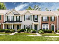 Charming townhouse with a well-manicured lawn, green door, shutters, and inviting curb appeal at 12328 Jessica Pl, Charlotte, NC 28269