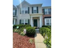 Charming townhome with a well-maintained front yard and a welcoming green front door at 12328 Jessica Pl, Charlotte, NC 28269
