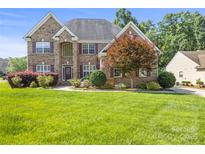 Charming brick home with manicured lawn, colorful landscaping, and lovely curb appeal in a desirable neighborhood at 128 Sugar Thyme Ln, Mooresville, NC 28115