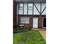 Charming brick townhome with well-maintained lawn and white-trimmed windows near the front door at 1300 Larchmont Pl, Salisbury, NC 28144
