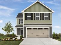 Charming two-story home features a two-car garage, landscaped yard and inviting front door at 1307 Elm Forest Ln, China Grove, NC 28023
