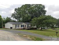 Charming single-story home with a cozy front porch and well-maintained lawn at 13211 Asbury Chapel Rd, Huntersville, NC 28078