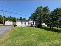Charming single-story home featuring a spacious front yard and a detached garage at 13211 Asbury Chapel Rd, Huntersville, NC 28078