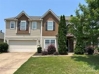 Charming two-story home with a two-car garage, stone facade accents, and a well-maintained lawn at 15105 Cavanshire Trl, Charlotte, NC 28278