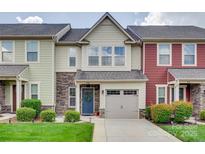 Charming townhouse featuring a stone facade, blue front door, and attached one-car garage at 318 Willow Wood Ct, Matthews, NC 28104