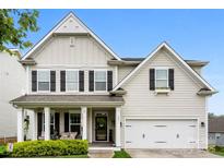 Charming two-story home featuring black shutters, a covered porch, and an attached two-car garage at 537 Lakeview Dr, McAdenville, NC 28101