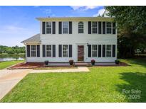 Charming two-story home with classic shutters and manicured lawn overlooking the serene lake at 6516 Laurel Springs Ct, Charlotte, NC 28227
