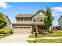 Charming two-story home featuring a manicured lawn, two car garage, and delightful curb appeal at 7263 Waterwheel Sw St, Concord, NC 28025