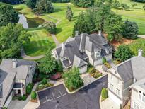 Stunning aerial view of an estate home on a golf course with a pond and lush landscaping at 8026 Greenview Terrace Ct, Charlotte, NC 28277