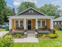 Charming mustard-color home with welcoming front porch and meticulously landscaped yard at 904 Anderson St, Charlotte, NC 28205